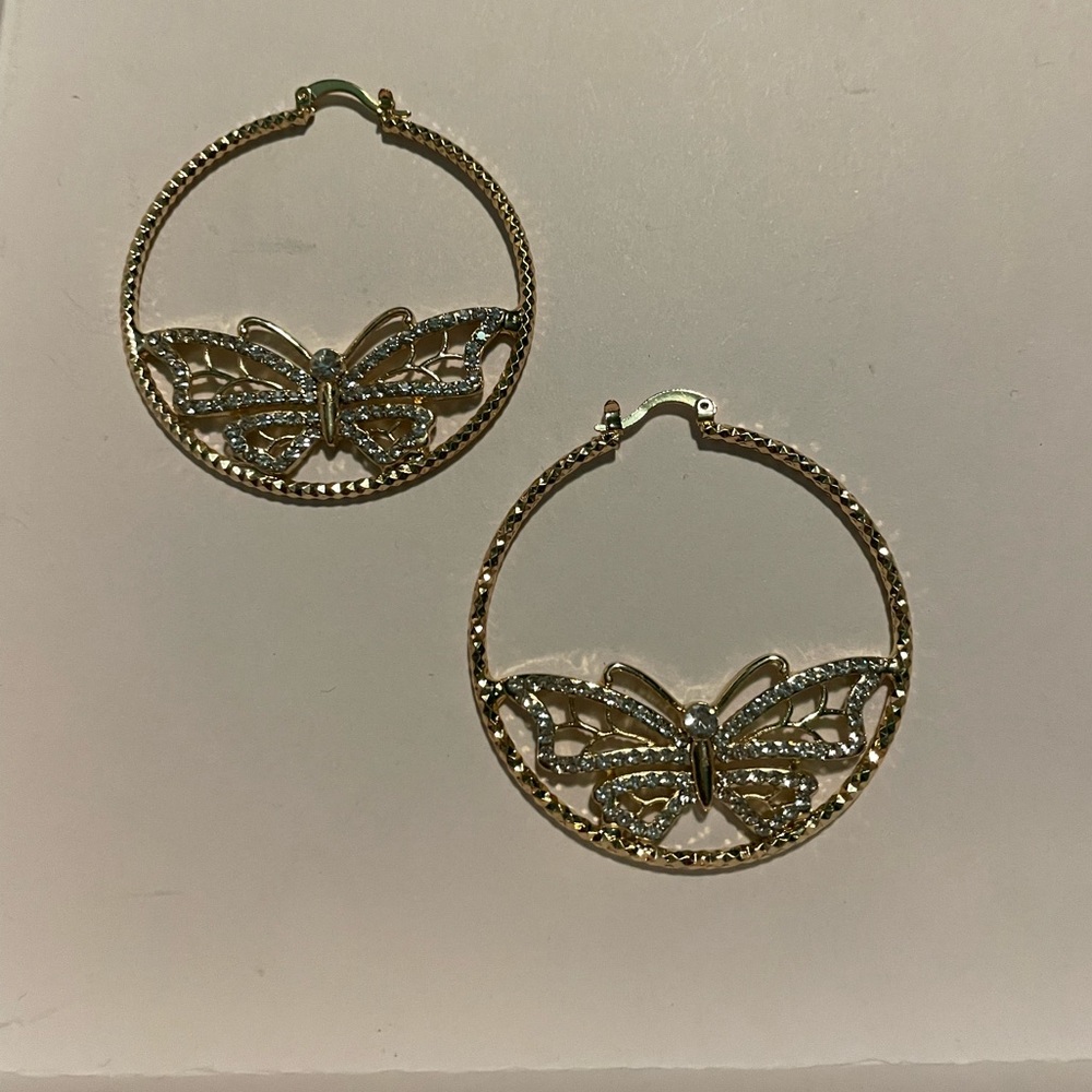 Gold colored hoop earrings with butterfly in the middle with tiny QZ gems